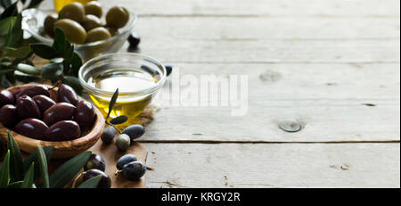 Olivenöl und Oliven auf Holz Hintergrund Stockfoto