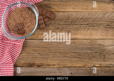 Geriebener Schokolade in eine Glasschüssel auf dem alten Holztisch. Stockfoto