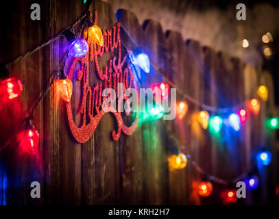 Frohe Weihnachten Urlaub kommen, Zeichen und bunte Lichter sind um uns Stockfoto