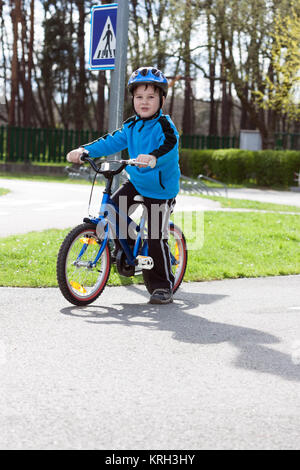 Kind auf dem Fahrrad auf der Asphaltstraße am Verkehrsgarten Stockfoto