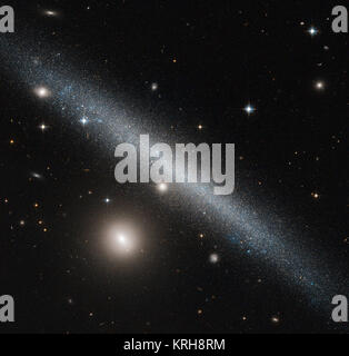 Die Galaxie drastisch über den Rahmen der NASA/ESA Hubble Space Telescope Bild ist ein leicht verzogen Zwerggalaxie wie UGC 1281 bekannt. Hier von einer Kante gesehen - auf Perspektive, diese Galaxie liegt etwa 18 Millionen Lichtjahre entfernt im Sternbild Triangulum (das Dreieck). Die hellen Begleiter, mit dem unteren linken von UGC 1281 ist die kleine Galaxie PGC 6700, offiziell bekannt als 2 MASX J 01493473 +3234464. Andere prominente Stars, die zu unserer eigenen Galaxie, der Milchstraße, und entfernteren Galaxien gesehen werden kann den ganzen Himmel verteilt. Der Seitenansicht haben wir von UGC 1281 macht es zu einem p Stockfoto