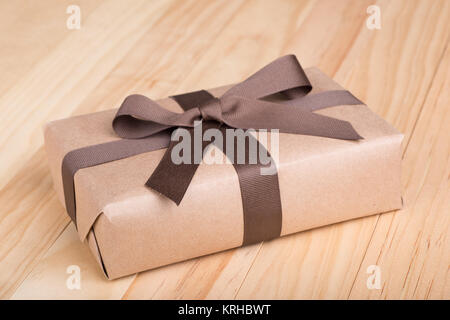 Geschenkpaket in Braun Band und Bogen auf Holz Oberfläche verpackt Stockfoto