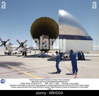 Mitglieder der und Bodencrews vorbereiten Ausrüstung von der NASA-B 377-SGT Super Guppy Turbine Cargo Aircraft auf der Rampe des NASA Dryden Flight Research Center auf der Edwards Air Force Base, Calif. Die überdimensionalen Frachtflugzeug die neueste Version der X-38 Flight Test Fahrzeug zu NASA Dryden geliefert hatte, als dieses Foto am 11. Juni 2000 getroffen wurde, zu entladen. Die B-377 SGT Super Guppy Turbine entwickelte sich aus den 1960er-Jahrgang Schwangere Guppy, Mini Guppy und Super Guppy, für den Transport von Teilen der Saturn Rakete für das Apollo Programm moon startet und andere großfrachten verwendet. Die verschiedenen Gupp Stockfoto