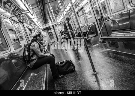 New York City, USA, 22. April 2017 - Woma hören Sie Musik während der Fahrt auf New Yorker U-Bahn Stockfoto