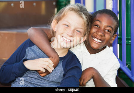 Glückliche junge Freunde sitzen zusammen Stockfoto