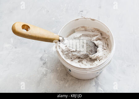 Metallspachtel im Topf mit Putty Stockfoto