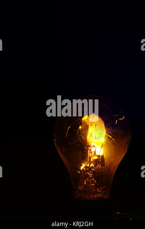 Defekte Glühbirne Tungsten Entzünden in Flammen und Rauch auf schwarzem Hintergrund Stockfoto