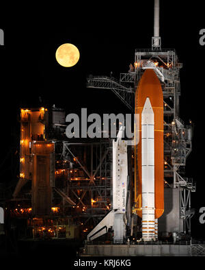 Eine fast volle Mond Sets wie der Space Shuttle Discovery auf dem Launch Pad 39 sitzt ein im Kennedy Space Center in Cape Canaveral, Florida, Mittwoch, 11. März 2009. Photo Credit: (NASA/Bill Ingalls) Space Shuttle Discovery und Mond Stockfoto