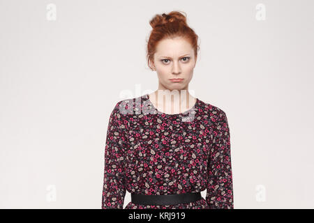 Schöne junge Frau an der Kamera suchen, zweifelnd und unschlüssig, Gesichtsausdruck, ihre Lippen zu verfolgen. Verwirrt junge beleidigte Frau isol Posing Stockfoto