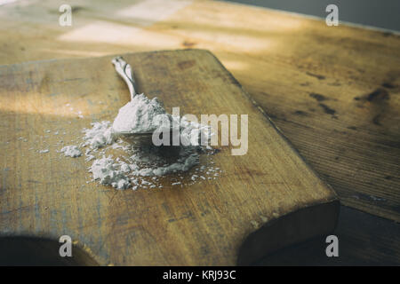 Silver Spoon mit maranta Pulver auf einem kleinen Holz Schneidebrett gefüllt. Stockfoto