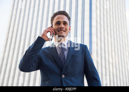 Freundliche stilvolle Geschäftsmann tragen Anzug und Telefonieren auf städtischen Hintergrund posiert. Stockfoto