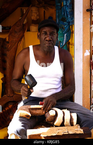 Eine bahamaische Holzschnitzer im Stroh Markt arbeiten in Nassau. Stockfoto