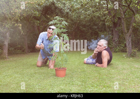 Senioren das Rauchen von Marihuana und entspannen im Garten Stockfoto