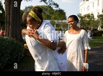 First Lady der USA Michelle Obama Uhren als Sasha Obama umarmt US-Präsident Barack Obama bei seinem 49. Geburtstag im Weißen Haus South Lawn August 8, 2010 in Washington, DC. Stockfoto