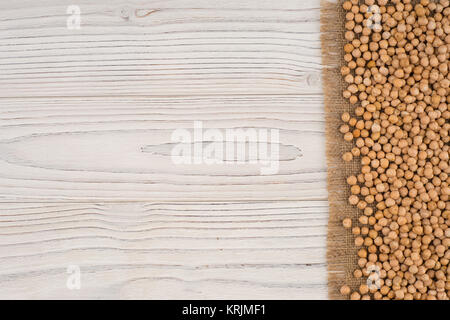 Kichererbsen auf Plünderungen und alte weiße Holztisch. Stockfoto