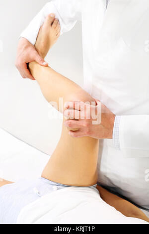 Orthopäden, Physiotherapeuten untersuchen Bein des Patienten Stockfoto