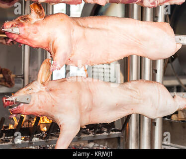 Schlachtkörper von Schweinefleisch und anderen Fleisch am Spieß. Stockfoto