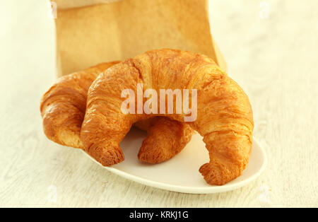 Eine ovale Platte mit zwei Croissants. isoliert auf weißem Stockfoto