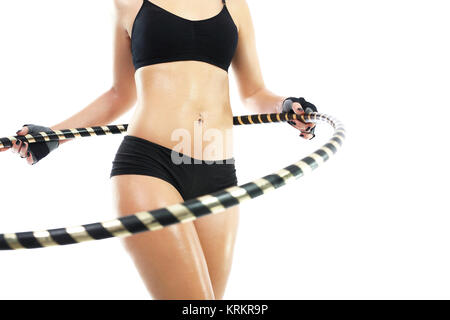 Flacher Bauch und Gesäß, die Frau, die Züge mit Rad hula Hop. Stockfoto