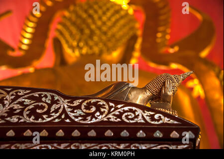 Bronze Buddha Statue in liegender Haltung mit der rechten Hand den Kopf, der lag auf einem Bett mit Palisander pearl Inlay. Stockfoto