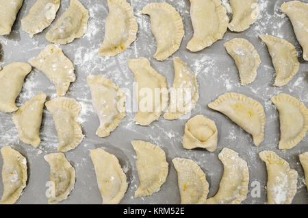 Traditionelle authentischen Nicht-inszenierten Polnische Weihnachten Piroggen auf Tisch in der modernen Küche zusammen mit einem ushko, während der Vorbereitung - Bereit zum Kochen. Stockfoto