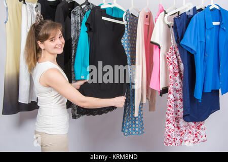 Mädchen wählt Kleidung und mit einem Lächeln, sah in den Rahmen Stockfoto