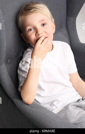 Porträt einer Junge sitzt auf einem Stuhl. Stockfoto