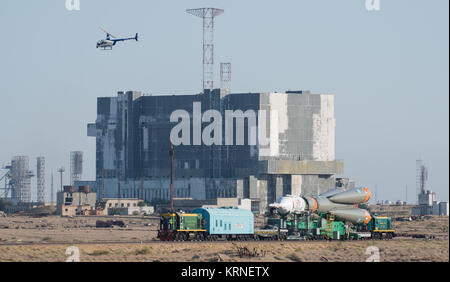 Ein Hubschrauber overhead fliegen wie die Sojus MS-05 Raumschiff wird durch Zug an der Startrampe auf dem Kosmodrom Baikonur, Kasachstan, am Mittwoch, 26. Juli 2017 eingeführt. Expedition 52 Bordingenieur Sergei Ryazanskiy von Roskosmos, Flight Engineer Randy Bresnik der NASA, und Flugingenieur Paolo Nespoli der ESA (European Space Agency), werden festgelegt, an die Internationale Raumstation an Bord der Sojus-Kapsel vom Kosmodrom Baikonur zu am 28. Juli. Photo Credit: (NASA/Joel Kowsky) Expedition 52 Rollout (NHQ 201707260015) Stockfoto