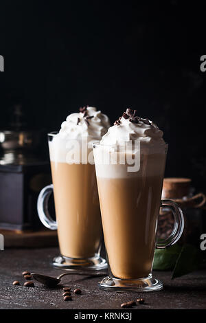 Kalter Kaffee trinken Frappe oder frappuccino, mit Sahne und Schokolade, Chips, mit Strohhalmen über dunklen Hintergrund Stockfoto