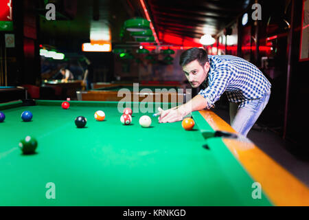 Hansome Mann spielen Pool Bar allein Stockfoto