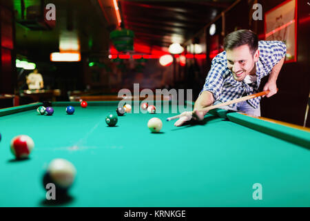 Hansome Mann spielen Pool Bar allein Stockfoto