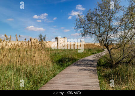 Die Wände, die die mittelalterliche Stadt Aigues-Mortes, vom Salt Marsh Gehweg gesehen. Aigues-Mortes, Frankreich. 2017. Stockfoto