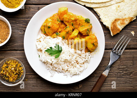 Chicken Curry mit Reis auf Holz- Hintergrund. Ansicht von oben, flach Stockfoto