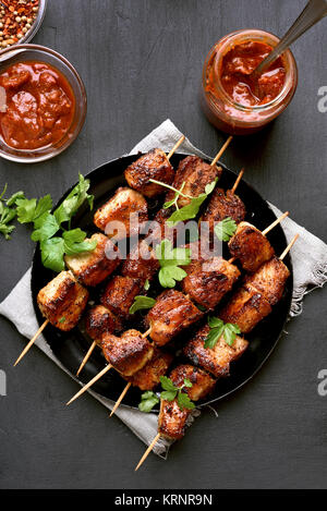 Schweinefleisch vom Grill Spieße auf schwarzen Hintergrund. Ansicht von oben, flach Essen Stockfoto