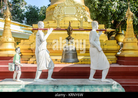 Foto von Statue, Kupfer Bell ist Durchführung von whiterobed Diakon, Kultur von Myanmar, Dez-2017 Stockfoto