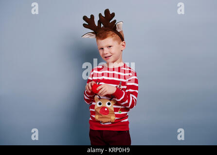 Süße Junge sieht aus wie Rentier Stockfoto