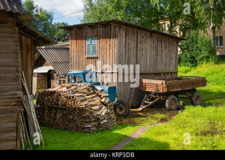 Traktor und geernteten Holz im Hof des Hauses Stockfoto
