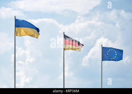 Die ukrainischen, Deutsche Fahnen und Flagge der Europäischen Union fluttern auf den Wind. Stockfoto