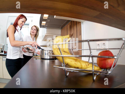 Zwei Junge Frauen Kochen Gemeinsam - zwei junge Frauen, die gemeinsam kochen Stockfoto