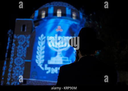 Ultraorthodoxer Jude sieht während des jüdischen Feiertags von Hanukka, dem Lichterfest, im jüdischen Viertel in der Altstadt von Jerusalem Israel eine Videoprojektion, die die jüdische Menorah über der rekonstruierten Hurva-Synagoge, auch bekannt als Hurvat Rabbi Yehudah HE-Hasid, zeigt Stockfoto