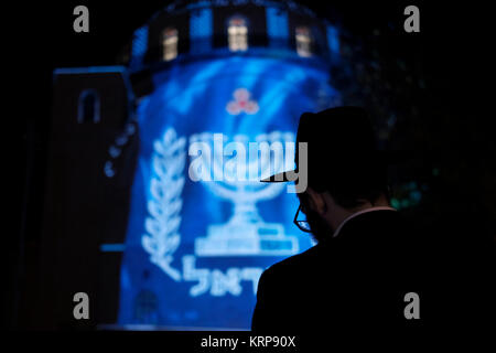 Ultraorthodoxer Jude sieht während des jüdischen Feiertags von Hanukka, dem Lichterfest, im jüdischen Viertel in der Altstadt von Jerusalem Israel eine Videoprojektion, die die jüdische Menorah über der rekonstruierten Hurva-Synagoge, auch bekannt als Hurvat Rabbi Yehudah HE-Hasid, zeigt Stockfoto