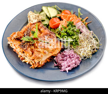 Vegetarische Lasagne mit Salat. Auf weissem Hintergrund Stockfoto