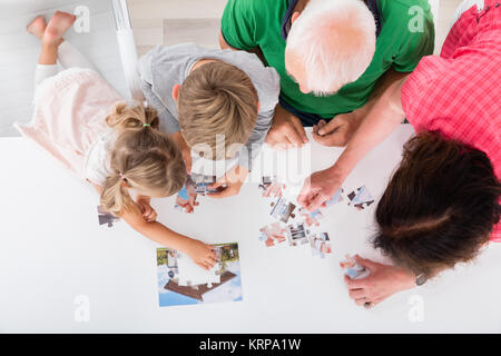 Multi-Generation Familie Lösung Puzzle zusammen zu Hause Stockfoto