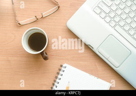 Laptop, Kaffee, Gläser und Notebook auf dem desktop Stockfoto