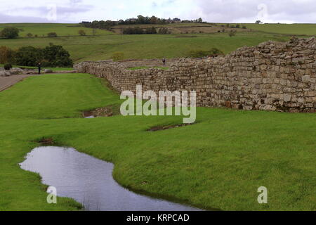 Die Äußere Mauer aus Stein von vindolanda Roman Fort, mit Regenwasser in der äußeren Graben in der Nähe der Stätte des antiken Feuer. In der Nähe von Hadrian's Wall, Northumberland, Großbritannien. Okt 2017. Stockfoto