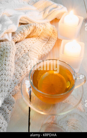 Gemütlich und weiche Winter Hintergrund. Warme Pullover oder Decken, Kerzen, Tasse Tee. Stockfoto