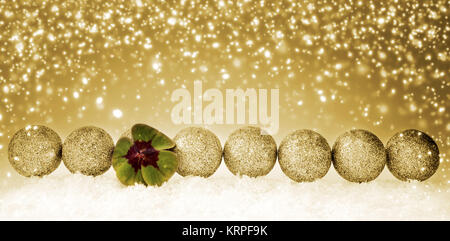 Grüne Kleeblatt und Weihnachtskugeln. Gerne Symbole: Four Leaf Clover und Schnee. Goldene Weihnachten Hintergrund. Stockfoto