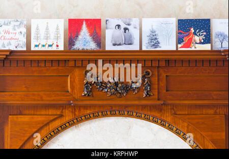 Reihe von Weihnachtskarten am Kamin in der Lounge des Hauses in Großbritannien Stockfoto