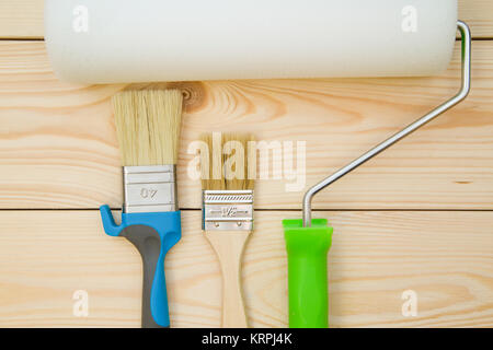 Eine Reihe von Pinsel und Roller für eine Reparatur eines leichten ungefärbt Holz- Hintergrund. Close Up. Ansicht von oben. Platz für Ihre Text- oder pruduct angezeigt. Stockfoto