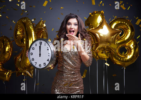 Aufgeregt Frau mit Uhr bei Foto Session's neues Jahr Stockfoto